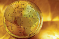 Photo illustration of globe made of gilded puzzle pieces.